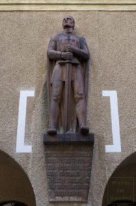 Terrakotta-Figur in Gestalt eines schwerttragenden Kriegers an der Fassade des Thuryhofs – darunter ein Spruch von Adolf Hitler.